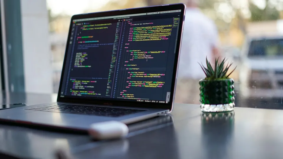 Laptop showing code on a desk
