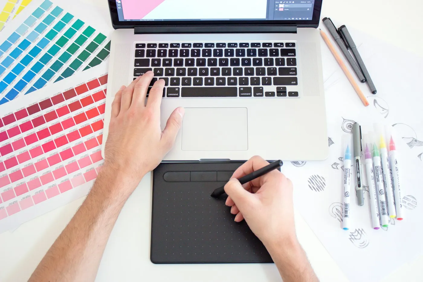 Designer sketching on a tablet next to colour swatches