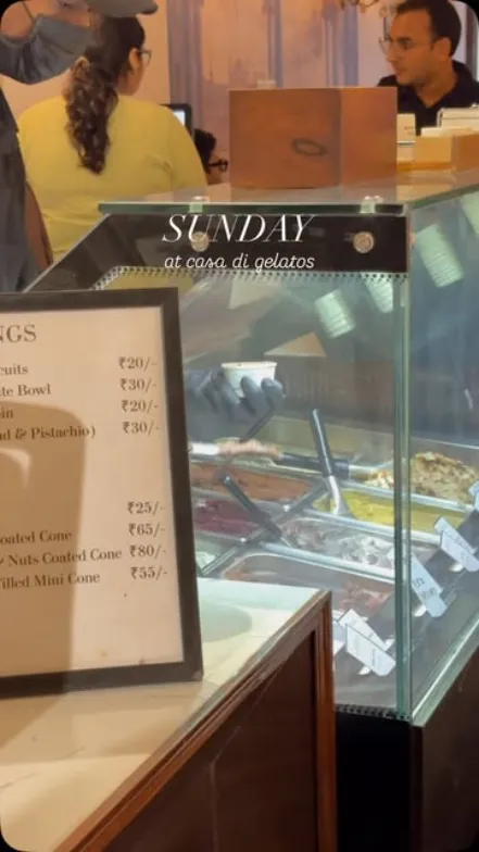 Busy gelato counter with the menu board on a Sunday